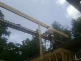 Carpenter setting a ridge beam over a new addition frame — Ice Dam Removal by Roofing Brothers in Wye Mills