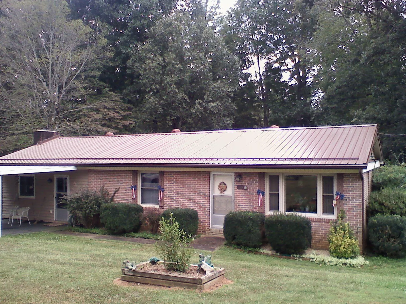 Bronze metal roof on a brick ranch home with a carport in Wye Mills