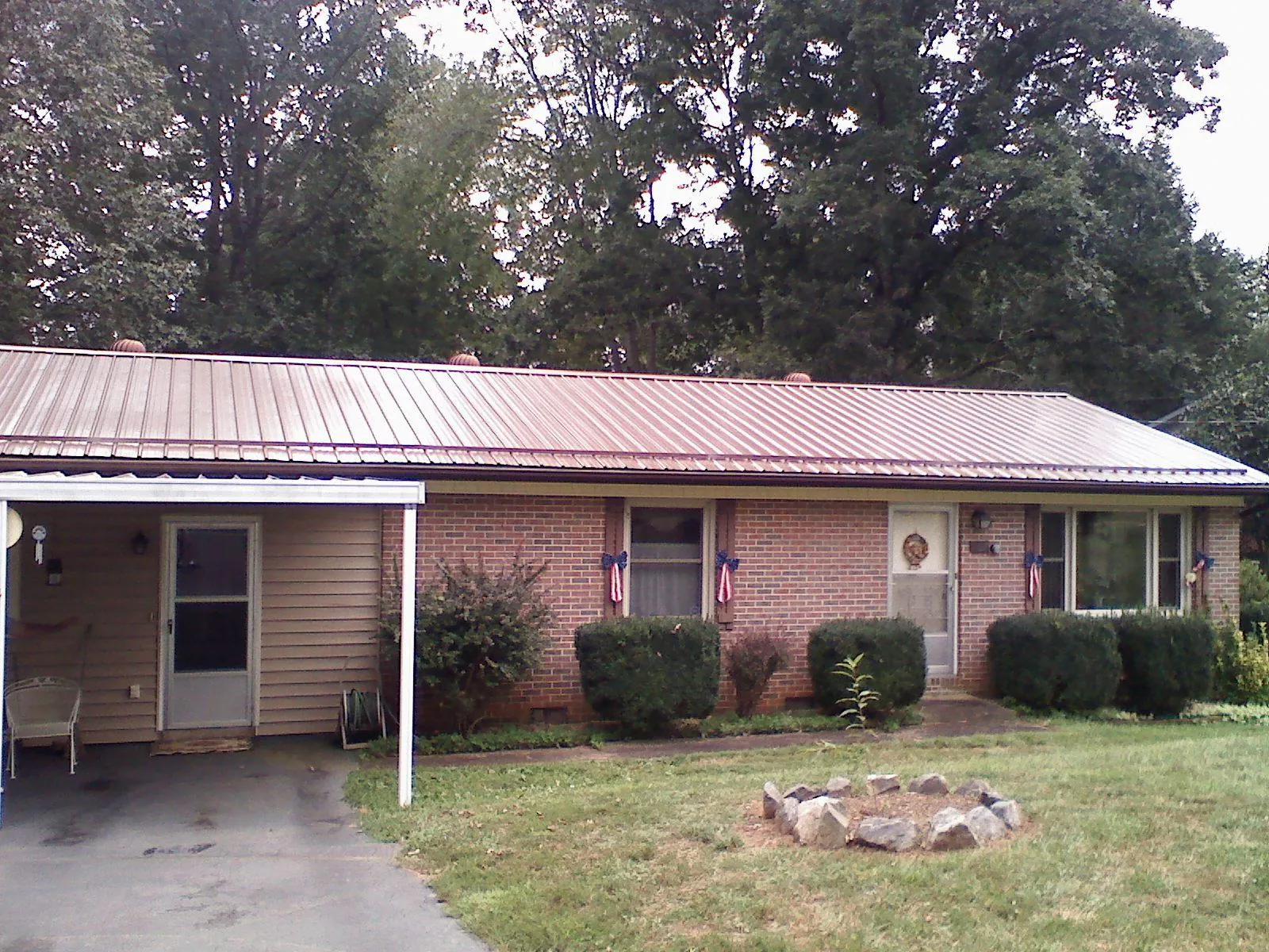 Bronze metal roof and carport on a brick ranch home — Roof Repair work by our crew in Wye Mills
